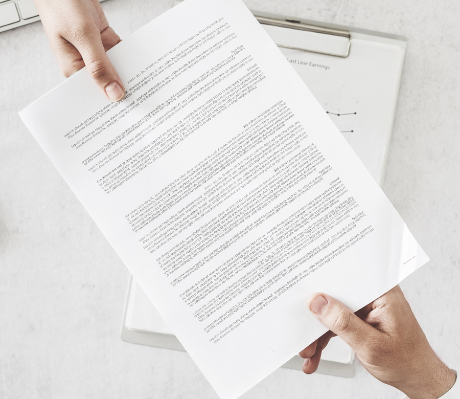 Two people holding either end of a piece of paper.